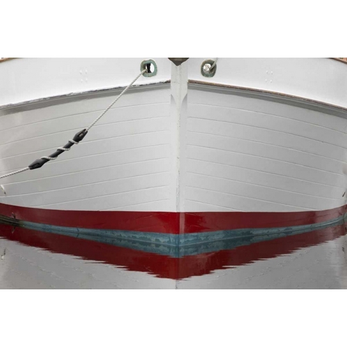 Alaska, Hoonah Bow of a boat reflects in water
